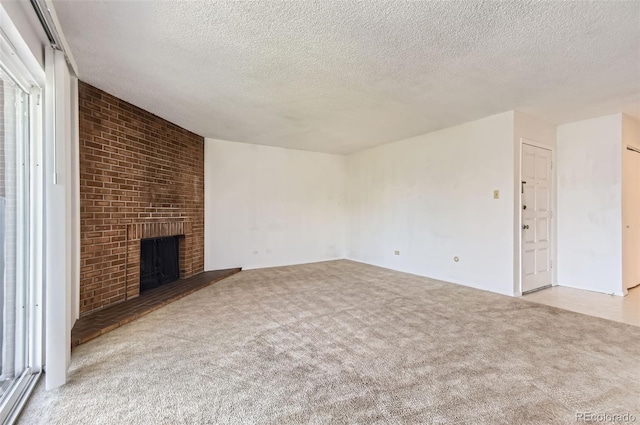 3436 S Locust St Unit D, Denver, CO 80222 - unfurnished living room with carpet flooring, a textured ceiling, and a brick fireplace