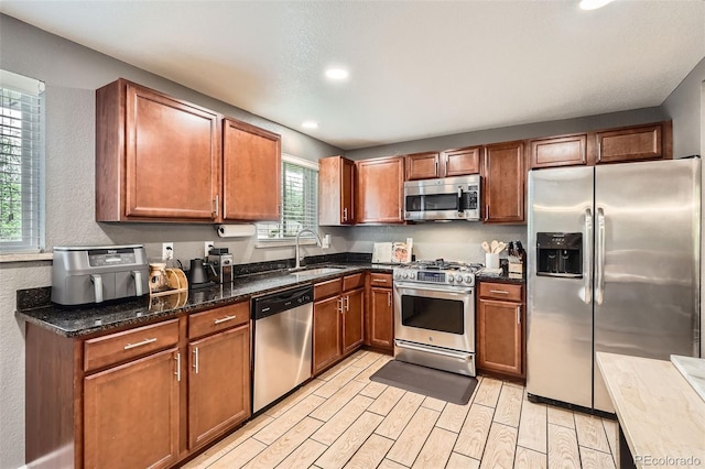 6046 Vrain St, Arvada, CO 80003 - kitchen featuring stainless steel appliances, a sink, wood finish floors, brown cabinetry, and recessed lighting