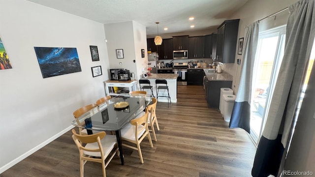 dining space featuring baseboards, dark wood-type flooring, and recessed lighting