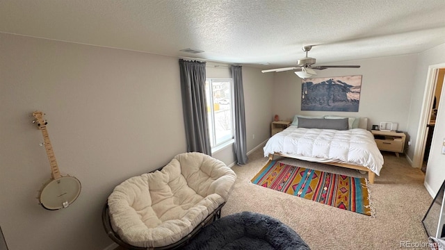 bedroom with baseboards, visible vents, light carpet, and a textured ceiling