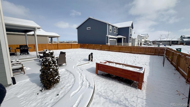 snowy yard with a fenced backyard and a residential view