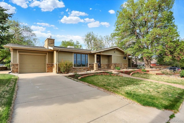 view of front of property with an attached garage, a chimney, driveway, a front yard, and stone siding