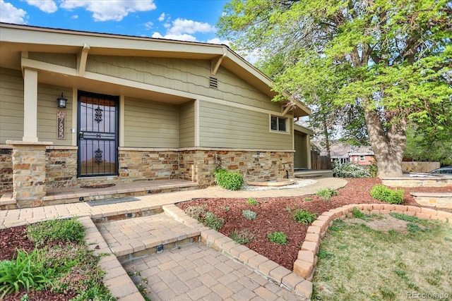 property entrance with stone siding