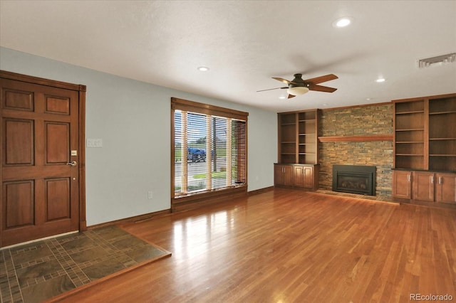 unfurnished living room with baseboards, recessed lighting, ceiling fan, built in shelves, and wood finished floors