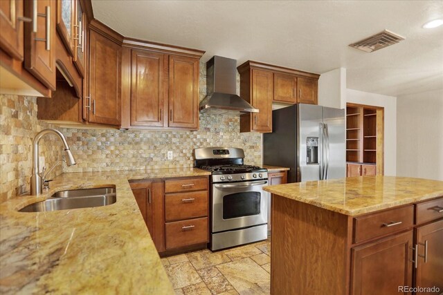 kitchen with wall chimney exhaust hood, appliances with stainless steel finishes, a sink, decorative backsplash, and recessed lighting