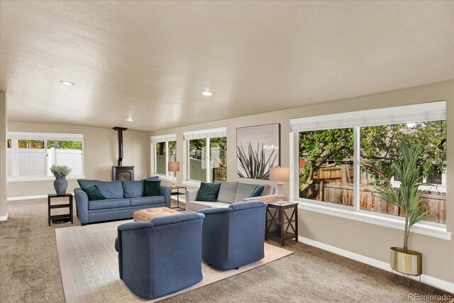 living area featuring a wood stove, carpet floors, baseboards, and recessed lighting