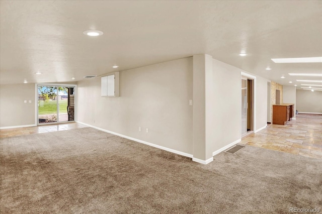 empty room featuring light carpet, recessed lighting, and baseboards