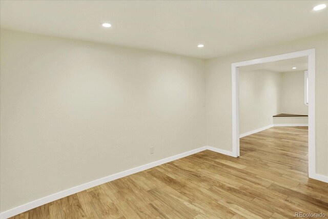 spare room with recessed lighting, light wood finished floors, and baseboards