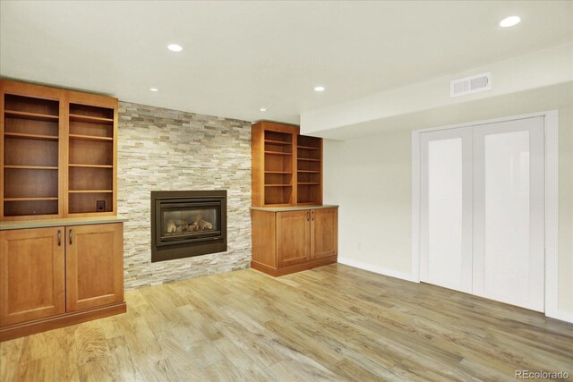 unfurnished living room with light wood-style floors, recessed lighting, and a large fireplace