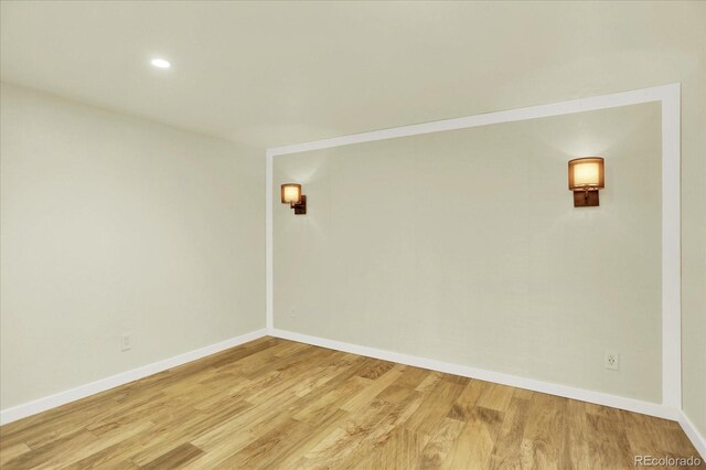 spare room with light wood-type flooring, baseboards, and recessed lighting