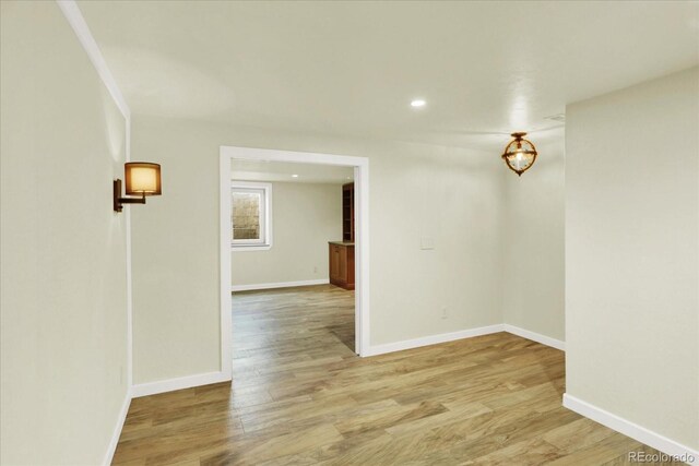 empty room with light wood-type flooring, baseboards, and recessed lighting