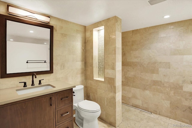 full bathroom with tile walls, toilet, vanity, and recessed lighting