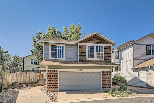 10440 W 83rd Ave, Arvada, CO 80005 - view of front facade featuring concrete driveway, brick siding, an attached garage, and fence