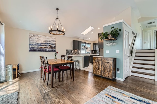 10440 W 83rd Ave, Arvada, CO 80005 - dining area featuring visible vents, a chandelier, dark wood-style floors, and lofted ceiling with skylight