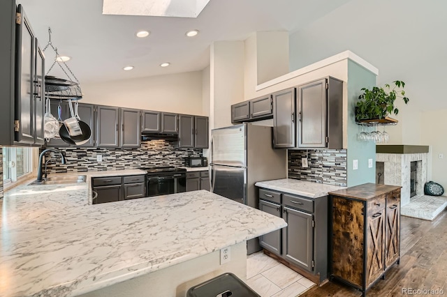 10440 W 83rd Ave, Arvada, CO 80005 - kitchen with decorative backsplash, a peninsula, extractor fan, black range with electric stovetop, and a sink