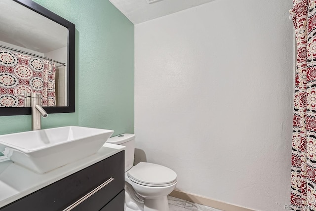 10440 W 83rd Ave, Arvada, CO 80005 - bathroom featuring toilet, a textured wall, marble finish floor, and vanity