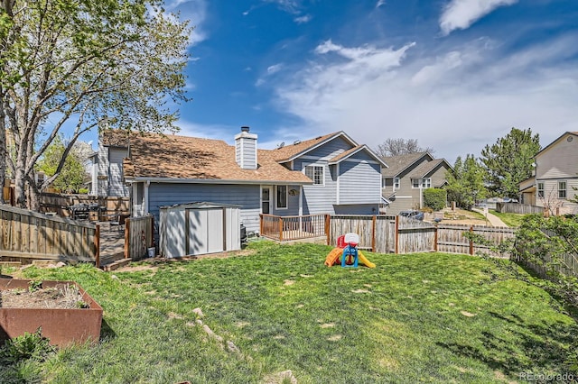10440 W 83rd Ave, Arvada, CO 80005 - back of property featuring a storage shed, a fenced backyard, a chimney, a garden, and a yard