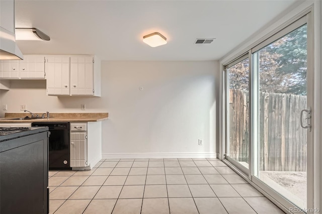 kitchen with white cabinetry, sink, black dishwasher, and light tile patterned floors