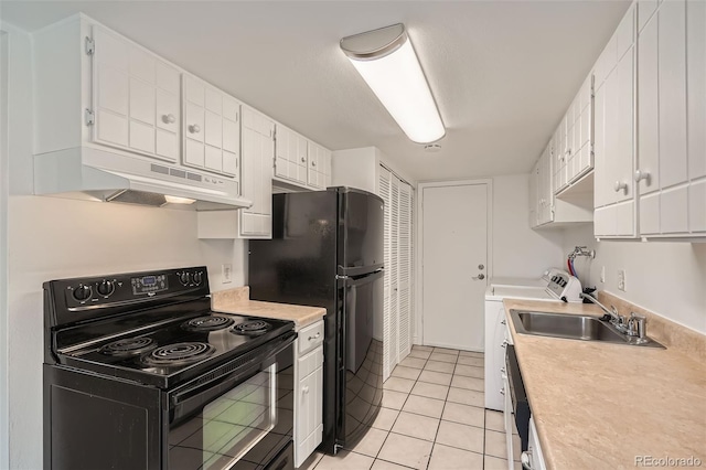 kitchen with white cabinetry, light tile patterned floors, black appliances, and washing machine and clothes dryer