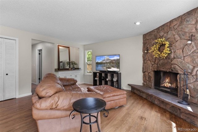 7951 S Webster Way, Littleton, CO 80128 - living room with a textured ceiling, wood finished floors, and a stone fireplace