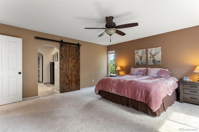 7951 S Webster Way, Littleton, CO 80128 - bedroom with arched walkways, light carpet, a barn door, and ceiling fan
