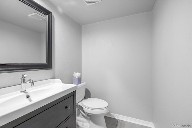 bathroom featuring vanity, hardwood / wood-style flooring, and toilet