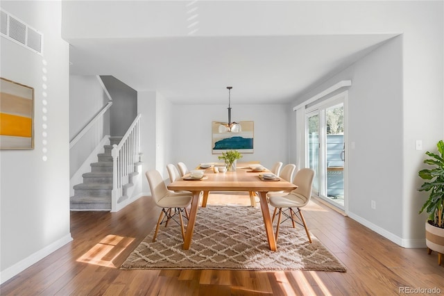 dining space with wood-type flooring