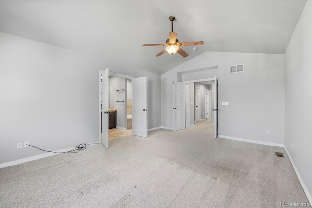 unfurnished bedroom featuring vaulted ceiling, light colored carpet, ceiling fan, and ensuite bathroom