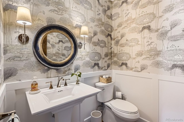 6102 S Aberdeen St, Littleton, CO 80120 - half bath featuring wallpapered walls, toilet, wainscoting, and a sink