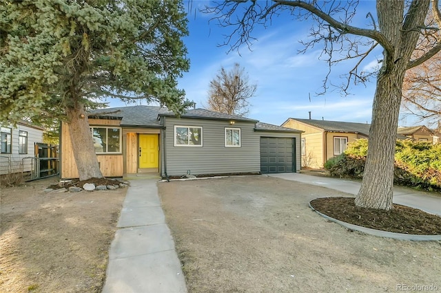 view of front of house with a garage, driveway, and fence