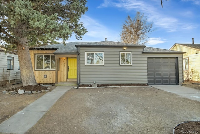 single story home featuring concrete driveway, roof with shingles, and an attached garage