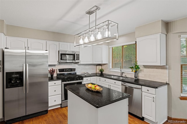 20922 E Crestline Cir, Centennial, CO 80015 - kitchen with appliances with stainless steel finishes, a sink, white cabinets, backsplash, and a center island