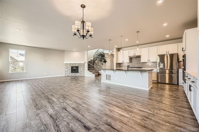1715 Pioneer Cir, Lafayette, CO 80026 - kitchen with stainless steel refrigerator with ice dispenser, open floor plan, dark countertops, decorative backsplash, and recessed lighting