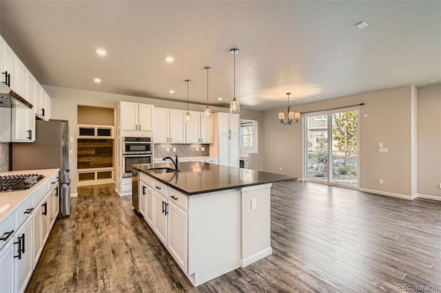 1715 Pioneer Cir, Lafayette, CO 80026 - kitchen featuring a sink, a chandelier, dark countertops, decorative backsplash, and dark wood-style flooring