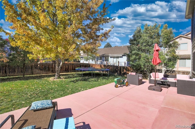 view of patio featuring a trampoline, a fenced backyard, and an outdoor living space