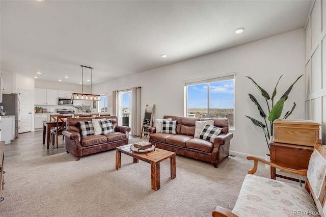 living area with recessed lighting and light carpet