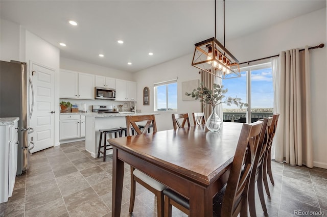 dining room with recessed lighting, a chandelier, and light stone finish flooring
