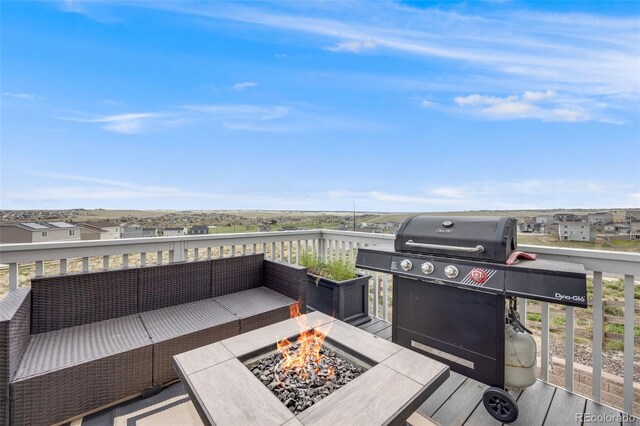 view of patio featuring grilling area, an outdoor living space with a fire pit, and a balcony