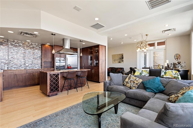 living room with visible vents and light wood-style flooring