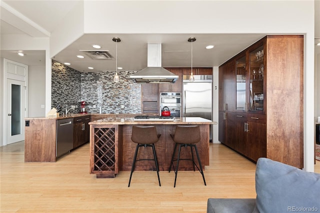 kitchen featuring stainless steel appliances, hanging light fixtures, extractor fan, and visible vents