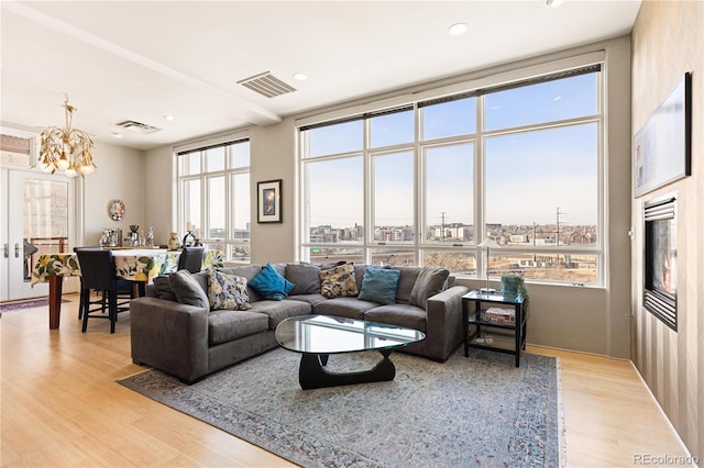 living room with plenty of natural light, light wood-style flooring, and visible vents