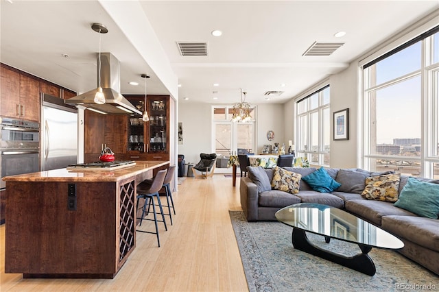 living area with light wood-type flooring, visible vents, a city view, and recessed lighting