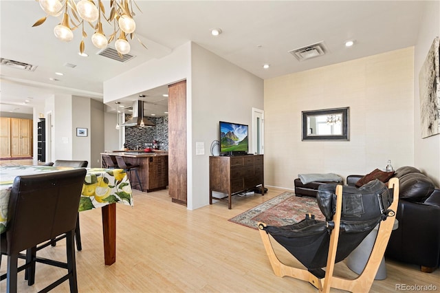 living room featuring light wood-style flooring, visible vents, and recessed lighting