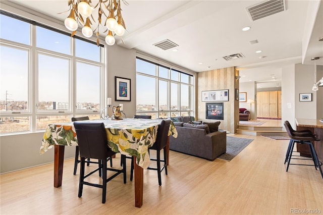 dining room featuring light wood-type flooring, visible vents, and a chandelier