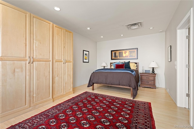 bedroom with light wood finished floors, visible vents, and recessed lighting