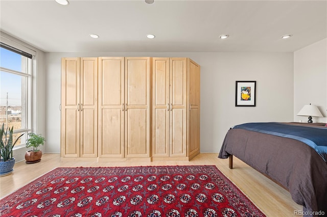 bedroom with light wood finished floors, multiple windows, and recessed lighting