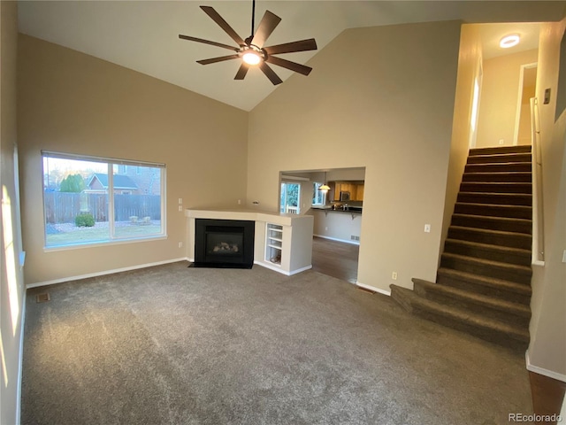 unfurnished living room featuring stairway, a healthy amount of sunlight, and ceiling fan