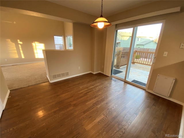 unfurnished room with dark wood-type flooring, baseboards, and visible vents