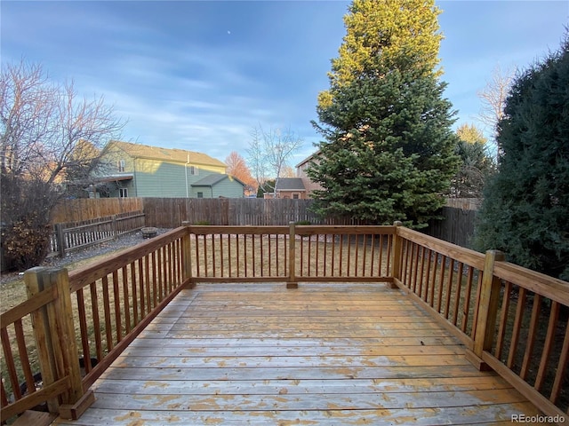 wooden deck with a fenced backyard