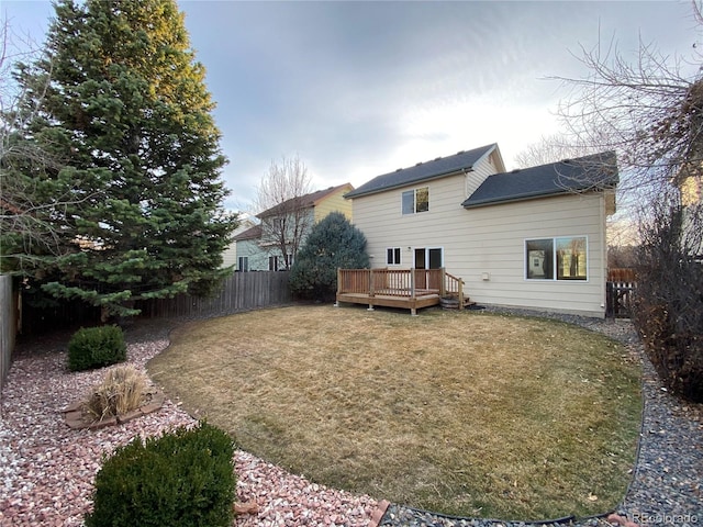 back of house with a yard, a wooden deck, a fenced backyard, and roof with shingles